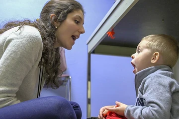 A Fredonia student works with a young client on speech exercises