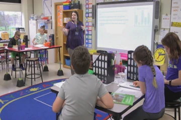 A fredonia student teaches students in a local classroom