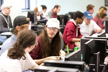 3 students talk while participating in a computer science competition