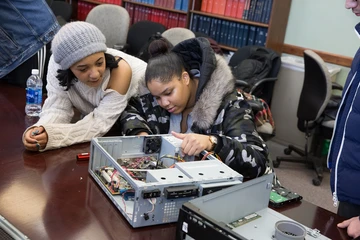 2 students work on a computer rebuilding project