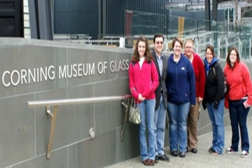 students pose for a photo at the entrance to Corning Museum of Glass