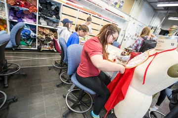 a student works on a costume in the costume shop