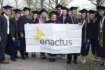 The enactus club poses for a group photo at commencement