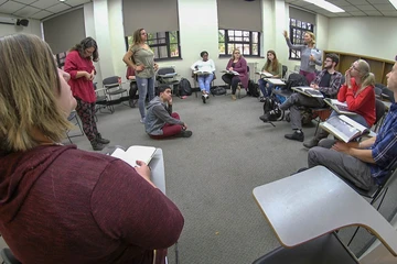 Students in Dr. Ann Seigle Drege's English class sit in a  circle and discuss Shakespeare