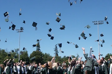 graduates throwing their graduation caps into the air in celebration