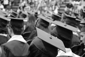 black and white image of graduation caps during a commencement ceremony