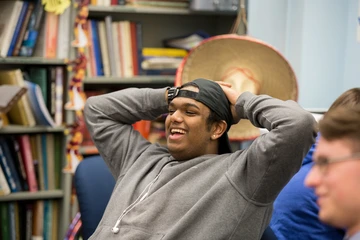 a student leans back and laughs during a conversation with the Math Club