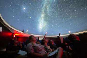 students look at the stars in the planetarium