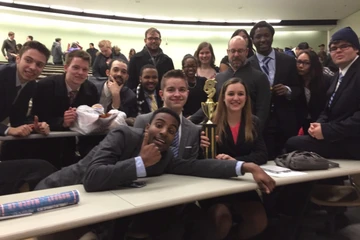 the mock trial team poses with a trophy after winning a competition