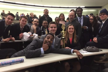 the mock trial team poses with a trophy after winning a competition