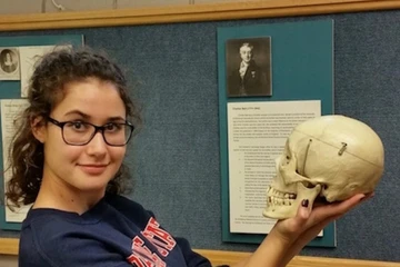 a student holds a model skull during a psych club activity. 