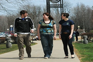 3 students walk across campus