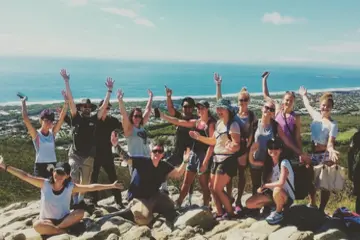 study abroad students pose for a group photo along a beach