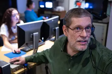 a faculty member directs sutdents during a tv production in the control room ofthe Thompson TV studio