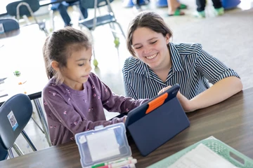 Fredonia education student works with a child at a tablet computer, Graduate child advocacy studies program, graduate child advocacy studies colleges in New York, graduate child advocacy studies majors in New York, graduate child advocacy studies degree