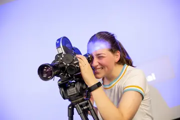 Fredonia student uses a camera, working in video arts, majoring in visual arts, new media in art, film & video arts colleges in New York