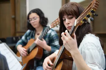 Fredonia students, like the woman playing guitar, can earn a music minor
