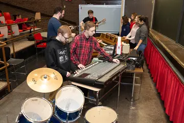 Fredonia students with musical instruments and a large, audio mixing board radio production, audio radio production program, audio radio production colleges in new york, audio radio production majors in new york, audio radio production degree