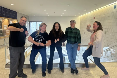 Digital photo of Honors student chosen (center) posing with four nominators.