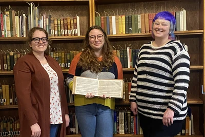 Angelina “Angie” Seamster (middle), displaying a book of sheet music, is joined by Katelynn Telford (left), music and arts librarian, and Amanda “Mandi” Shepp (right), coordinator of Special Collections & Archives.