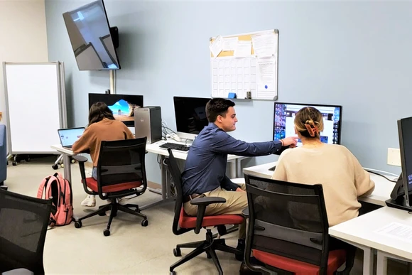 Students working together at computers in the studio