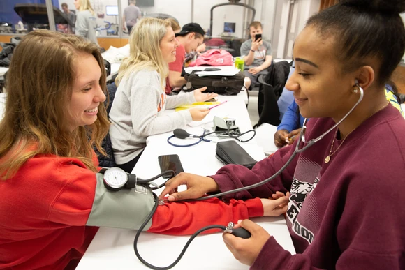 Fredonia biology students in a lab testing one another. Fredonia students majoring in biology, or earning a degree in biology can get a biology degree. 