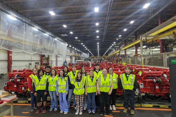 Students from Salamanca High School are pictured next at the Cummins Jamestown Engine Plant next to several large diesel engines.