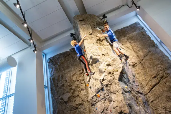 Fredonia students climbing a rock wall 