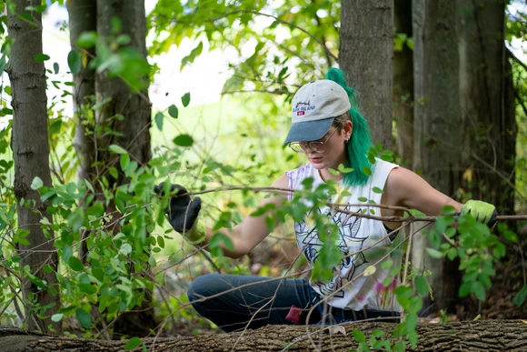 Fredonia student examining the forest floor. Students with a major in Biology can earn a degree in biology or a biology degree.