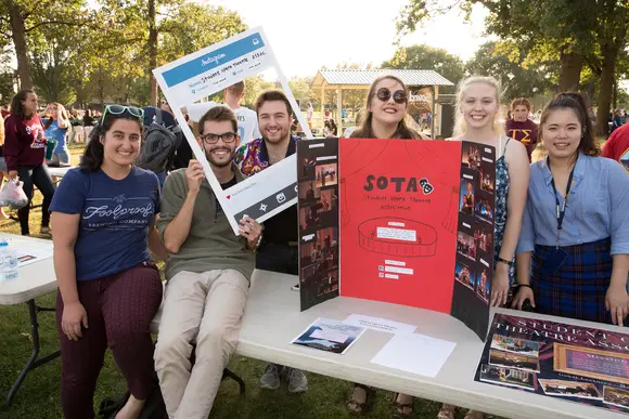 students pose at their clubs' table at Activities Night