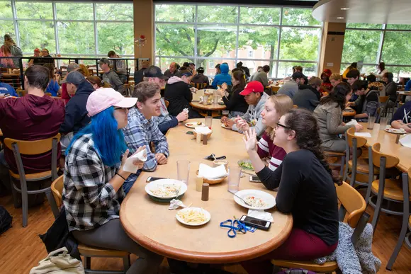 students chat while they eat lunch in the seating area of Cranston Marche