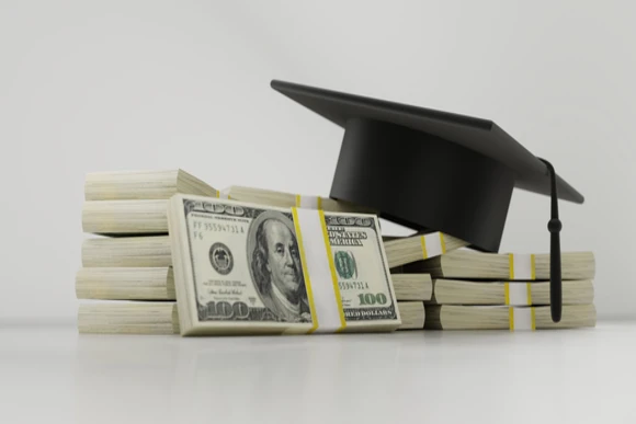 a photo of a pile of money and a graduation cap