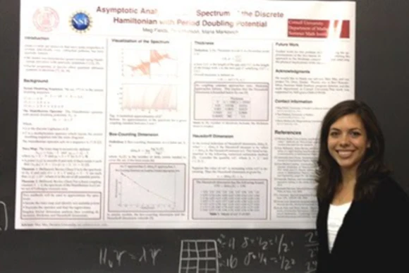 Student in front of research poster