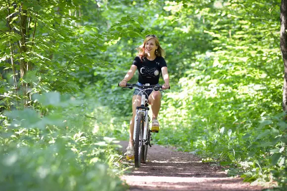 woman on a mountain bike in the forest, a great way to explore the region