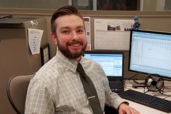 Student facing camera with computer in the background