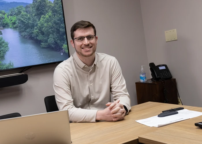 Business student seated at a table and smiling into the camera
