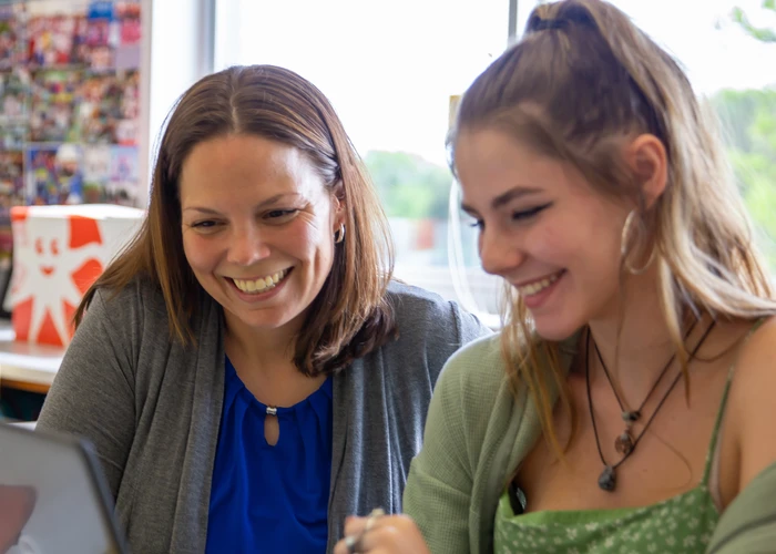 School leader working with a student in a classroom