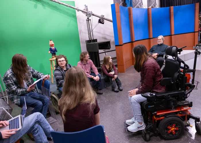 students in a class talking to their professor