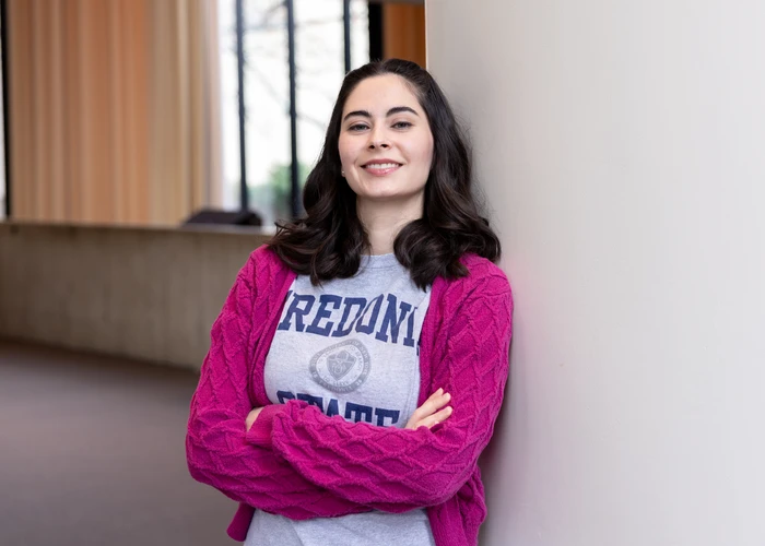 Fredonia student leaning against a wall