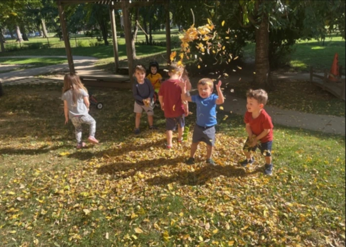 children playing in leaves on a fall day