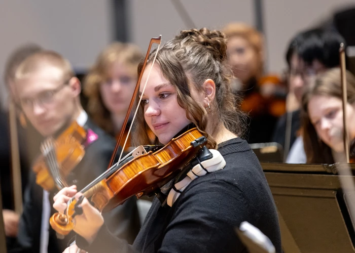 student playing violin in the college orchestra