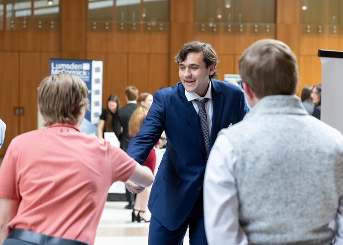 Fredonia student shaking hands at an event