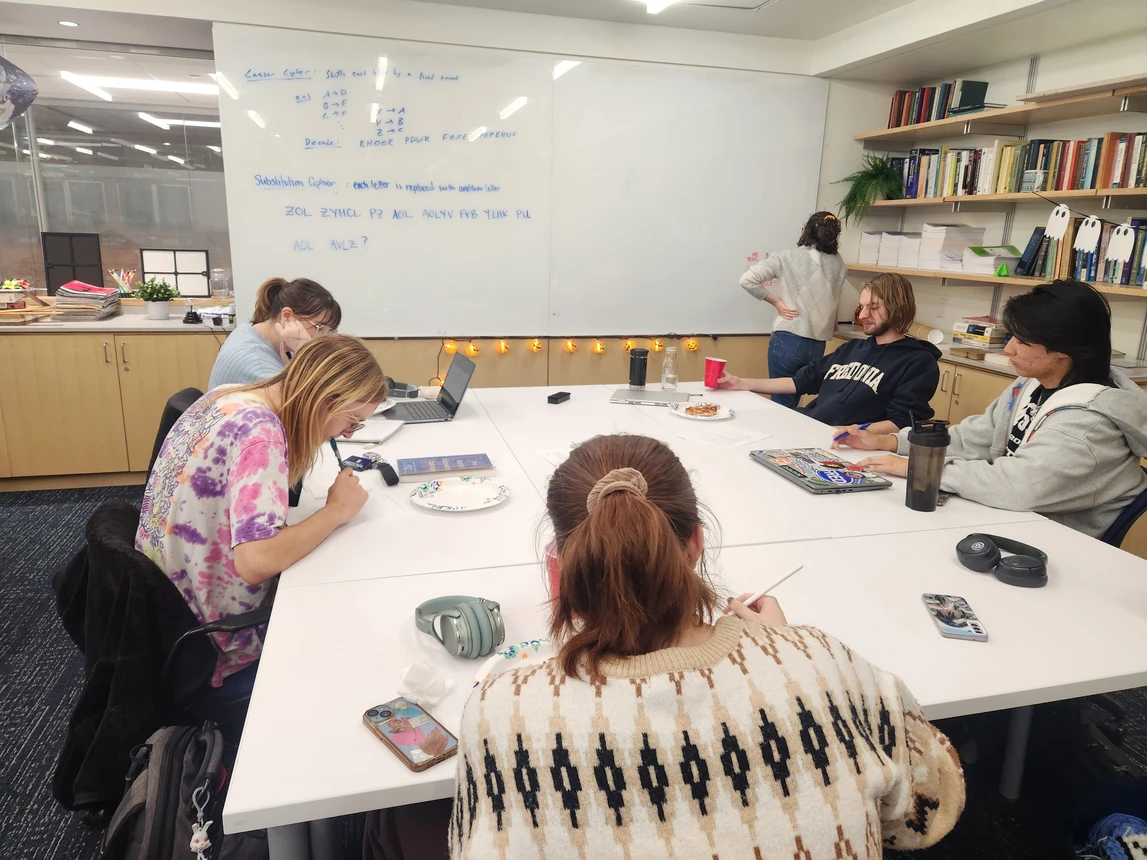 Students at a table working on decrypting a secret code