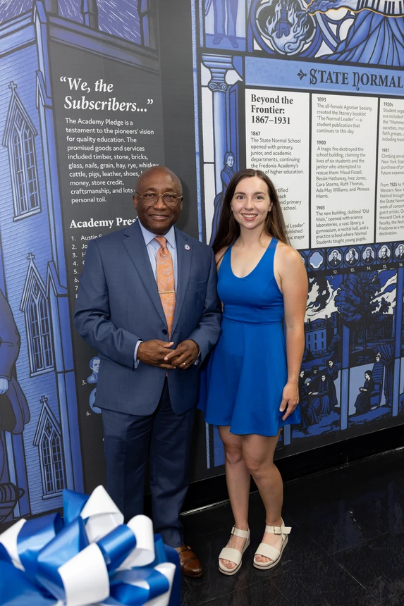 President Kolison and Erin Ruffino pose in front of the mural