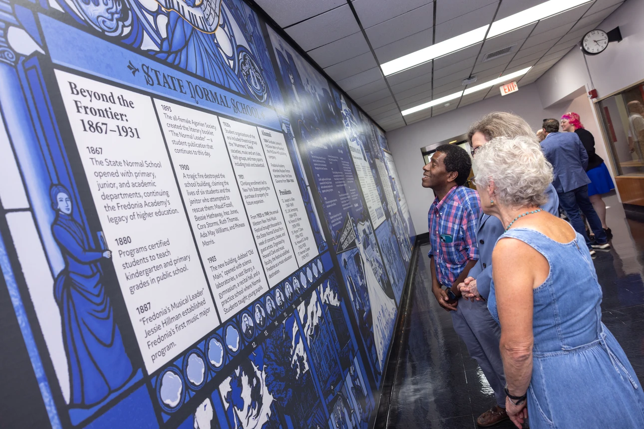 visitors look at the mural following ribbon-cutting ceremony