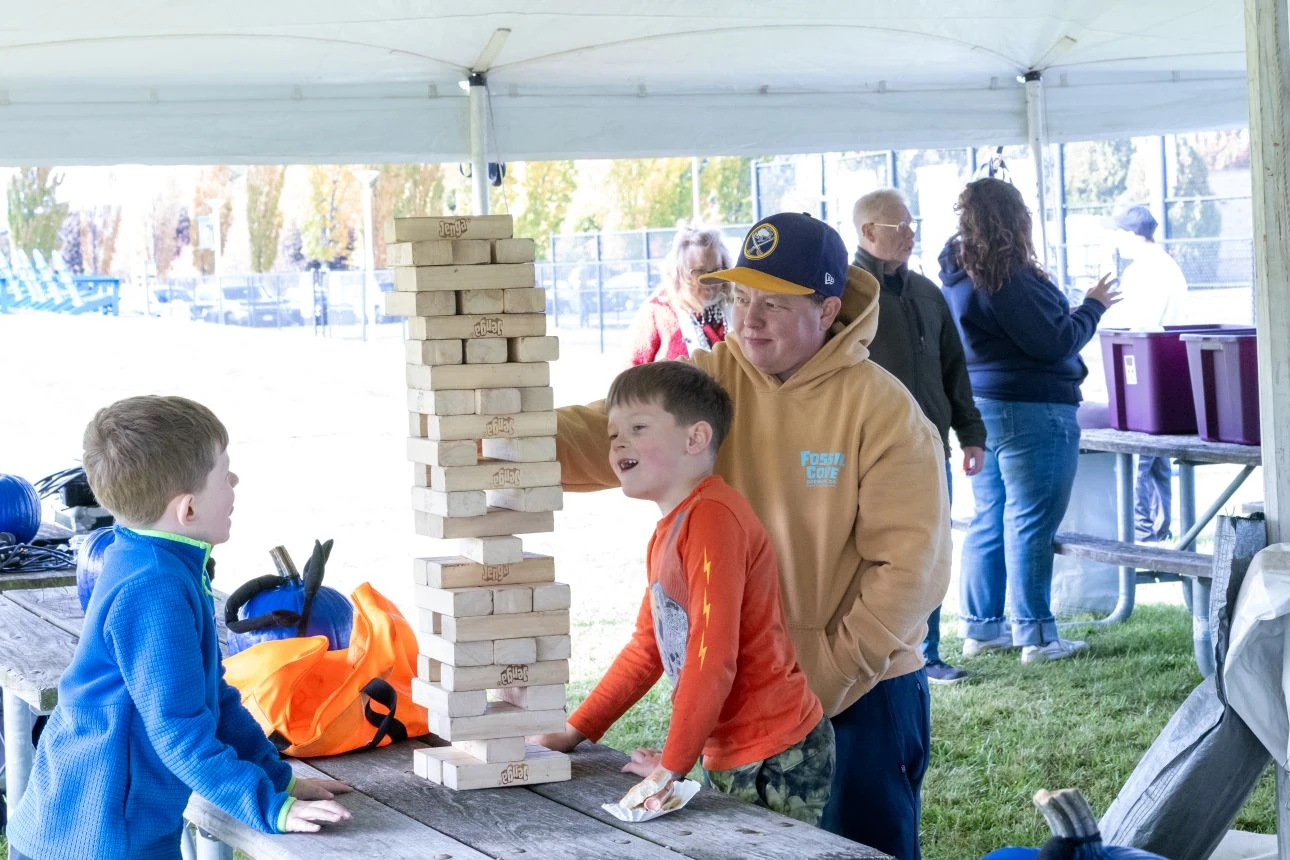 Adult and two children playing a wood block game