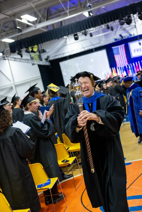 Faculty mace bearer smiling as he exits 