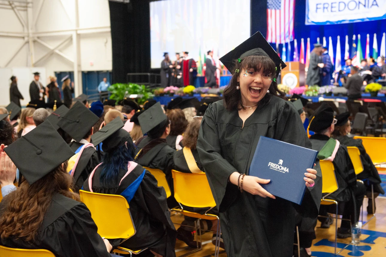 Graduate smiling as she returns to her seat 