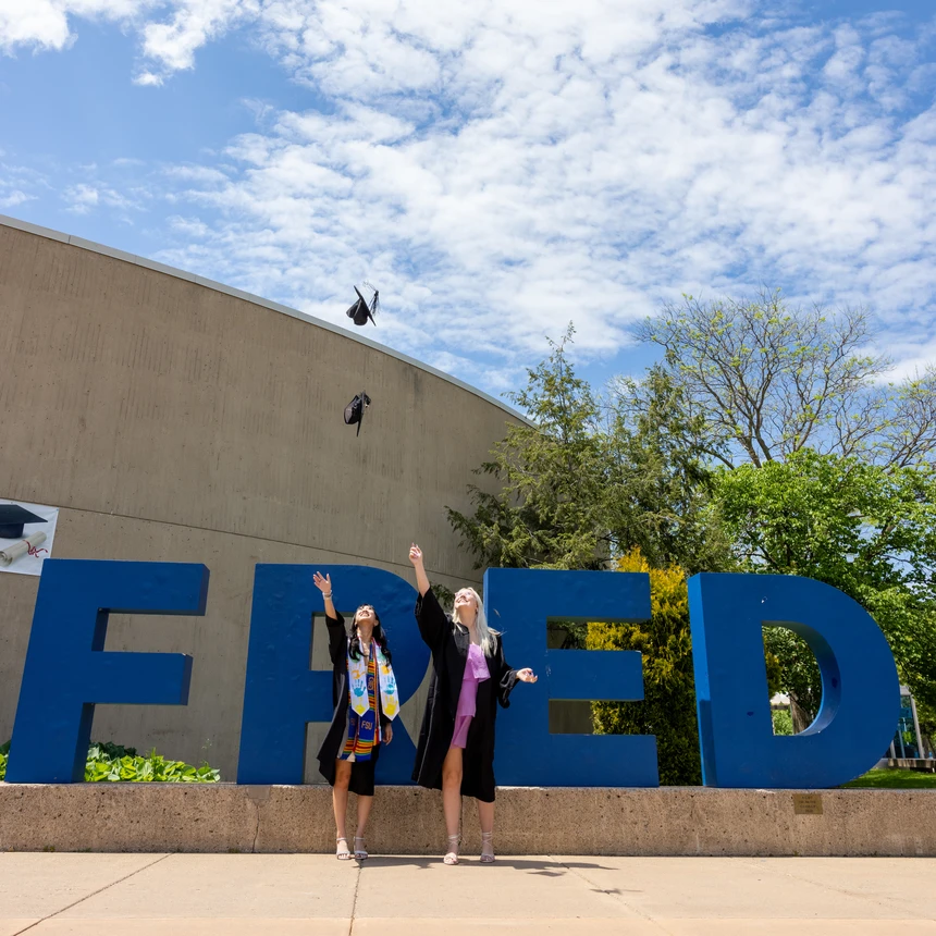 Graduates throwing mortar boards in the air 