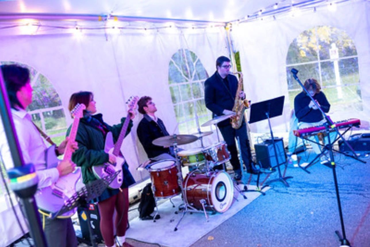 Musicians perform under a white tent